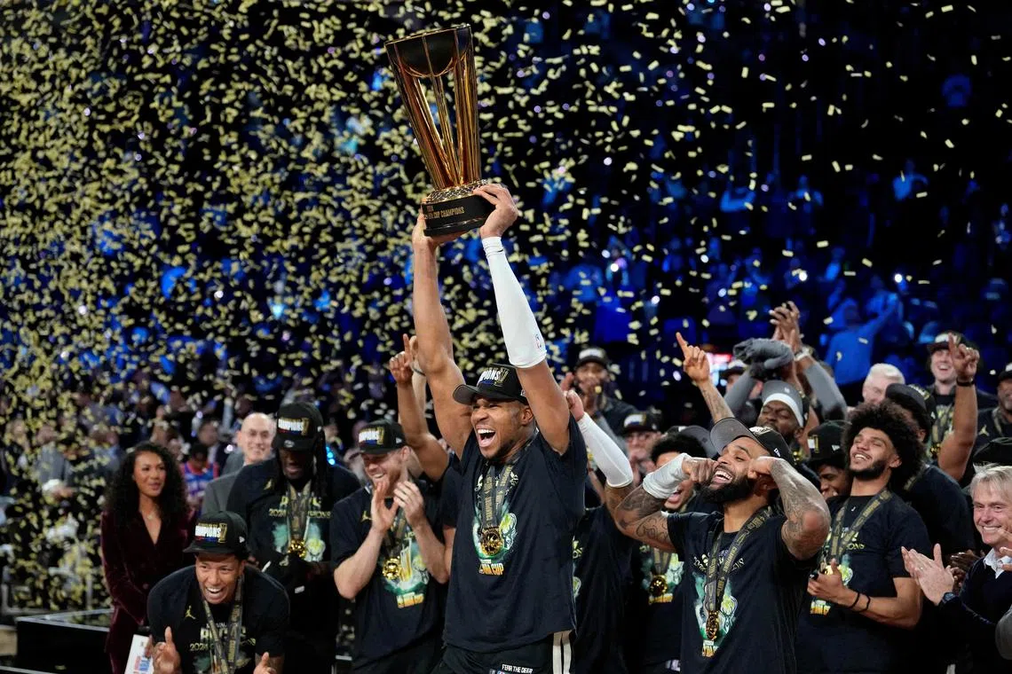 Milwaukee Bucks forward Giannis Antetokounmpo celebrates with the trophy and teammates after winning the NBA Cup against the Oklahoma City Thunder.