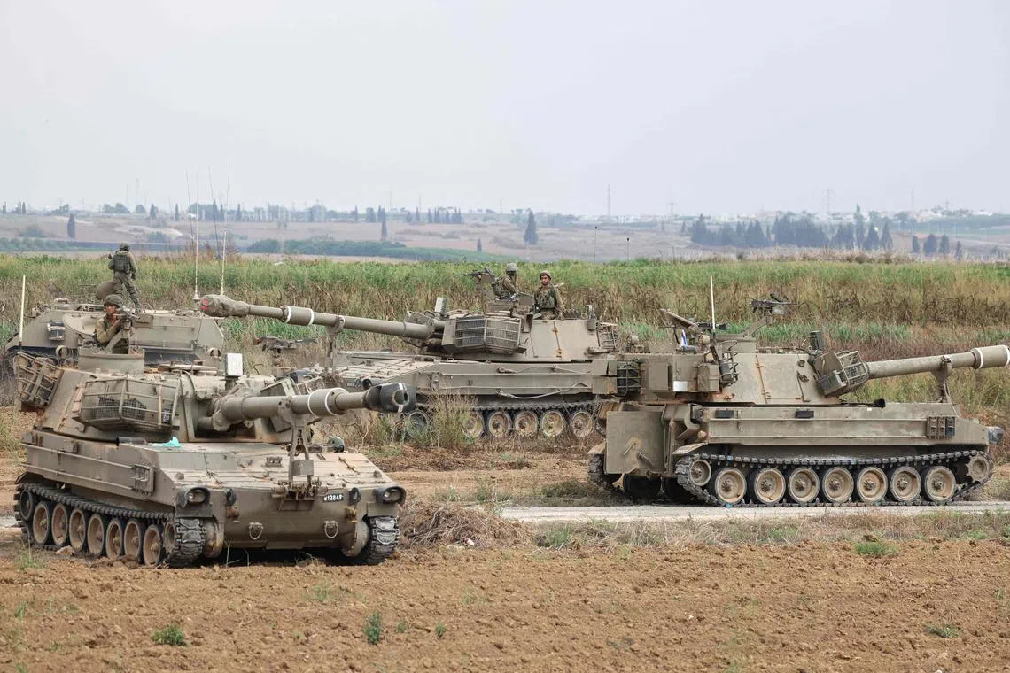 Israeli army soldiers with their armoured vehicles standing guard near the border with the Gaza Strip on Oct 9.