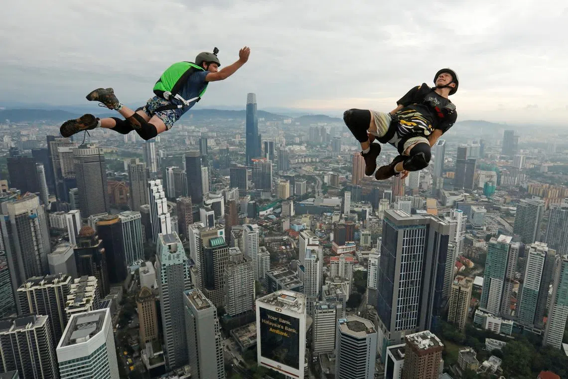 Base jumpers are airborne after leaping off the Kuala Lumpur Tower during the annual KL Tower International Jump Malaysia 2023 at Kuala Lumpur, Malaysia, Feb 3, 2023.