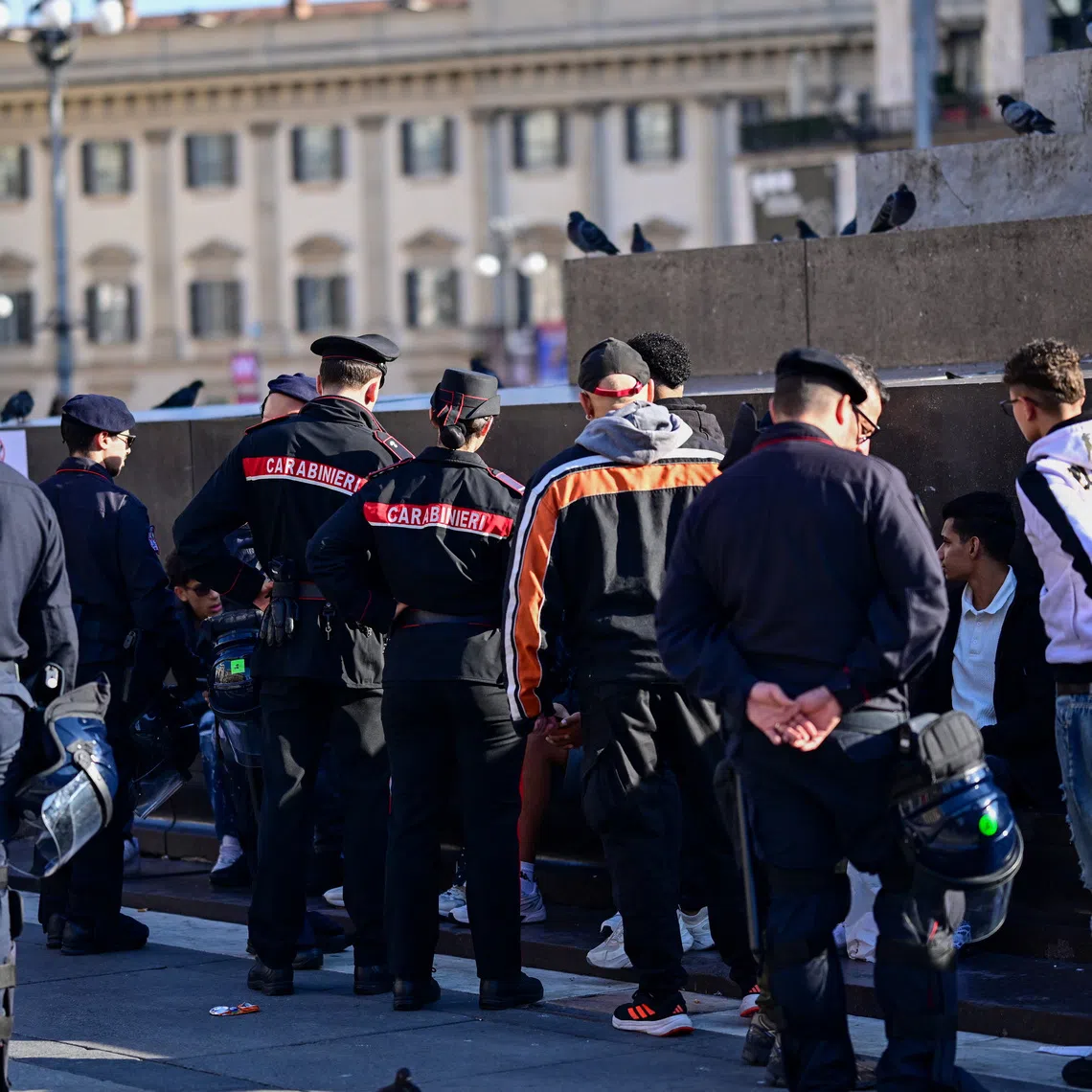 Carabinieri officers stand near a group of people in central Milan following a weekend of violent protests and unrest, in Milan, Italy, October 19, 2026. REUTERS/Daniele Mascolo