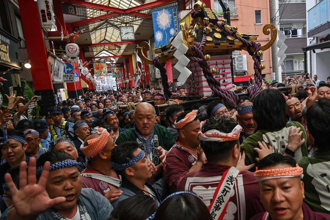 Participants carrying a portable shrine or "mikoshi" as they take part in the annual Sanja Matsuri Festival in the Asakusa district of Tokyo on May 18, 2025. Thousands of people flocked to Tokyo's Asakusa district during the annual three-day-long festival, which heralds the coming of summer in the Japanese capital. 