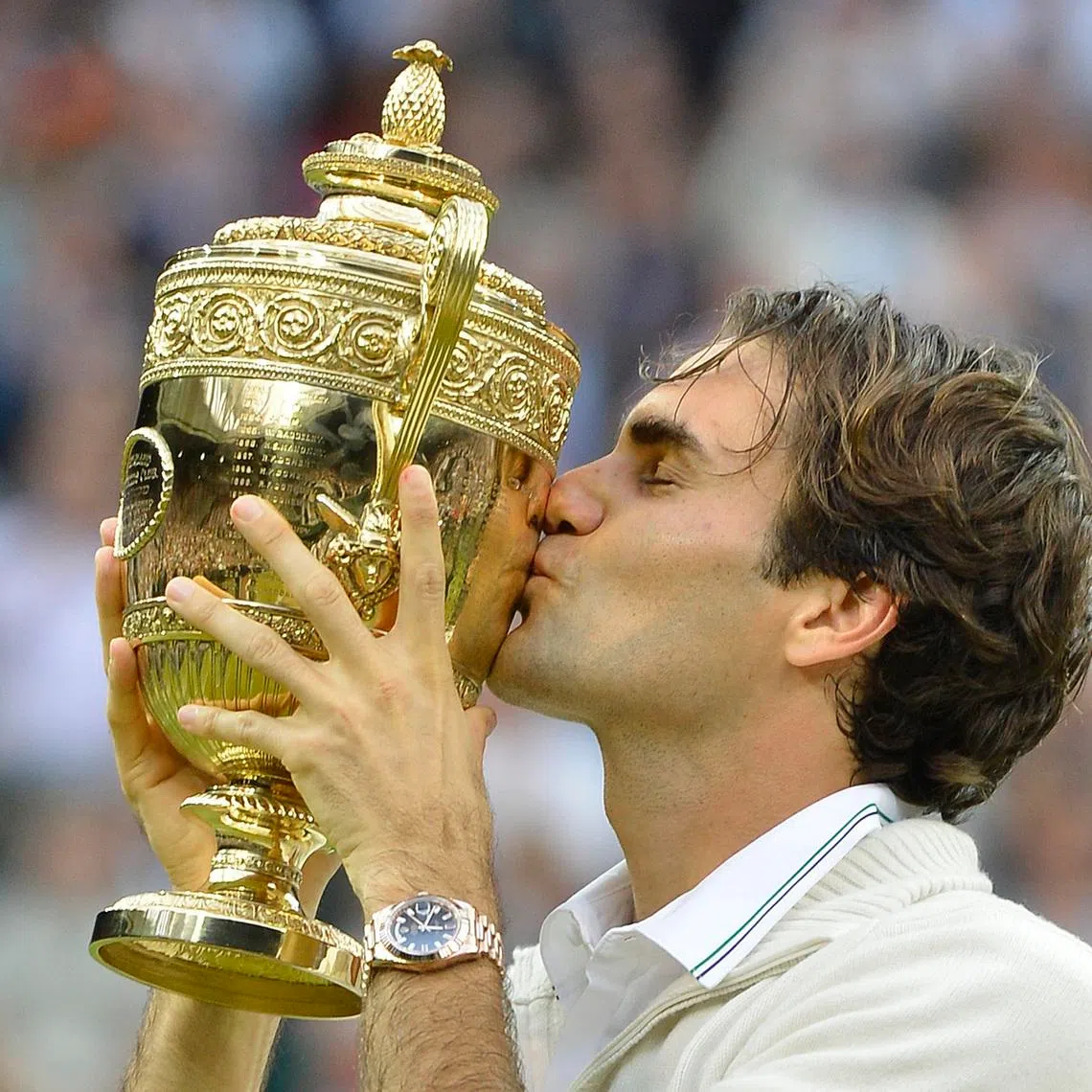 Roger Federer of Switzerland kisses the winner's trophy after defeating Andy Murray of Britain in their men's singles final tennis match at the Wimbledon Tennis Championships in London July 8, 2012. REUTERS/Toby Melville/File Photo