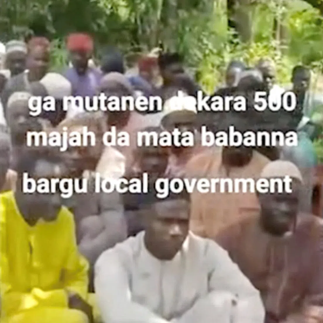 People sit on the grass in this screen grab obtained from a social media video released by an armed group on August 23, 2026, showing what residets said were about 600 women, children and older people abducted in an attack on a mosque in Nigeria’s north-central Niger State. SOCIAL MEDIA/via REUTERS