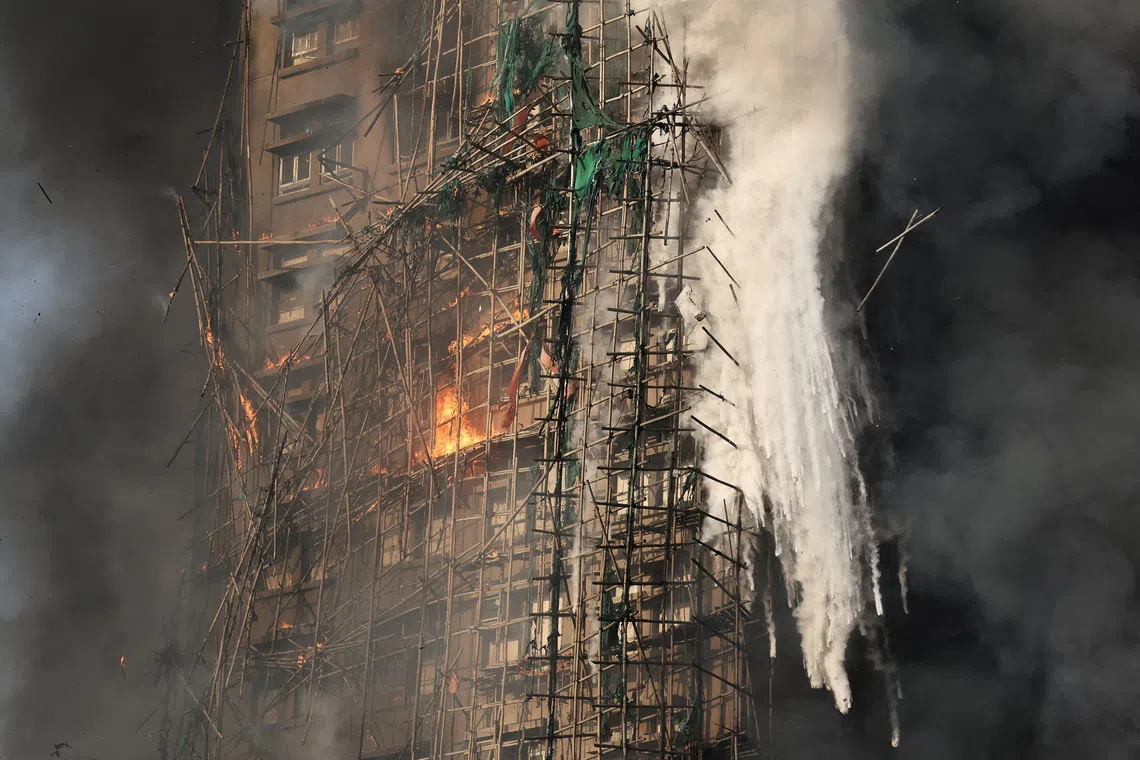 FILE PHOTO: Smoke rises while flames burn bamboo scaffolding on a building at Wang Fuk Court housing complex during a deadly fire in Tai Po, Hong Kong, China, November 26, 2025. REUTERS/Tyrone Siu/File Photo