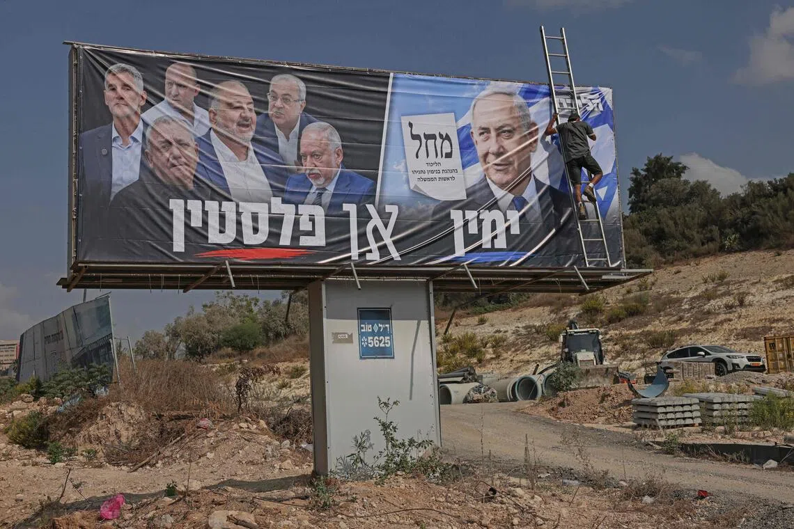 An electoral campaign billboard for Israeli Prime Minister Benjamin Netanyahu’s Likud party, with a Hebrew phrase reading “the Right or Palestine” alongside faces of the members of the opposition.