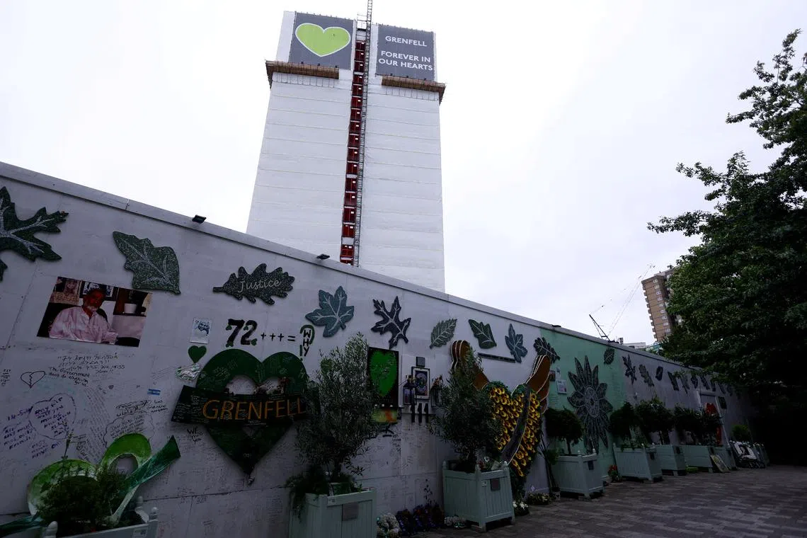 FILE PHOTO: The covered remains of Grenfell Tower are seen behind a wall of condolences, ahead of the publishing of the second report of the UK public inquiry into the deadly 2017 Grenfell fire, in London, Britain, August 22, 2024. REUTERS/Hannah McKay/File Photo