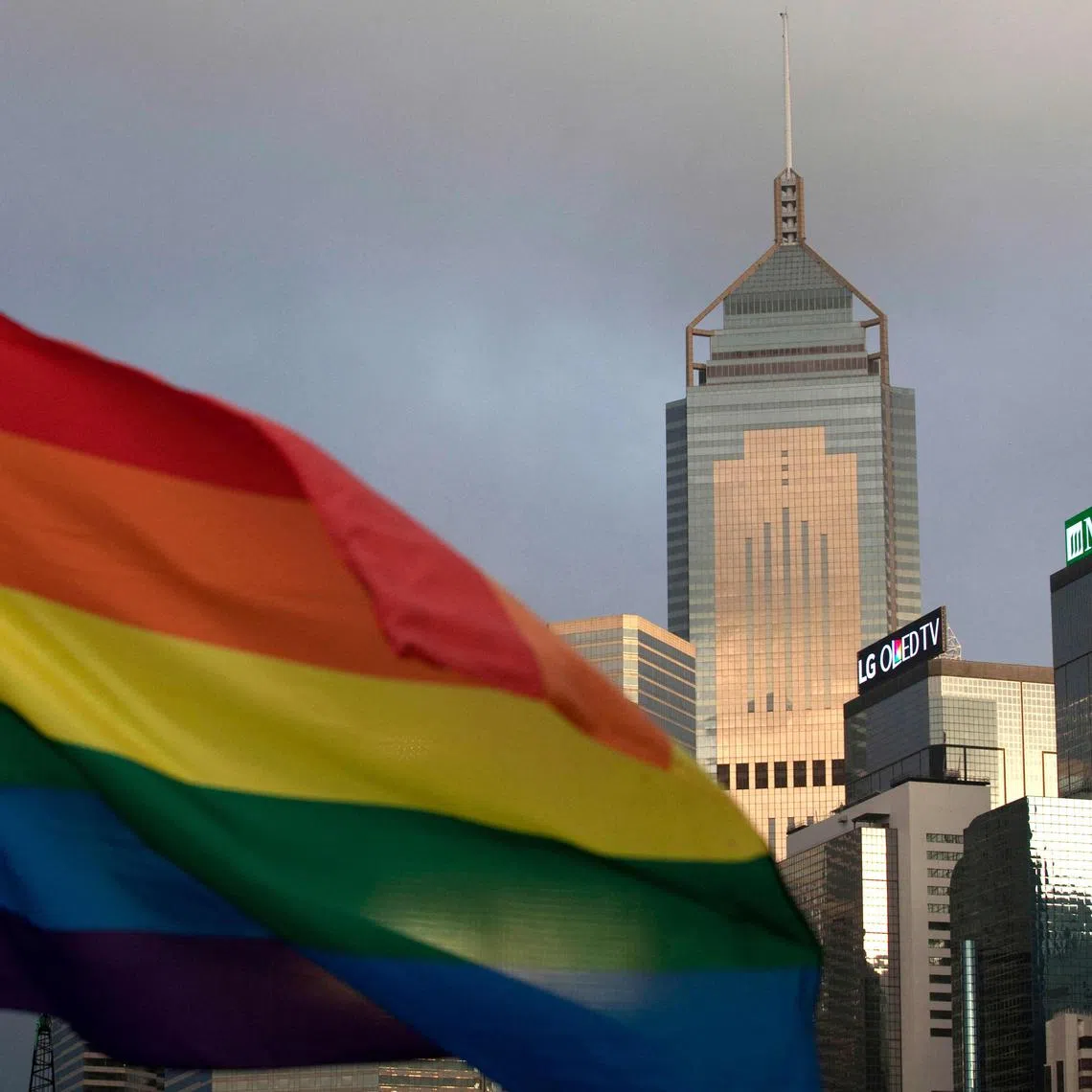 (FILES) A rainbow flag, a symbole of the LGBTQ community, is seen in front of the city skyline in Hong Kong on November 6, 2015. The Hong Kong government said on July 2, 2025 it will propose legislation to recognise some rights of same-sex couples whose marriages are registered abroad, to comply with a 2023 court judgment. (Photo by Isaac LAWRENCE / AFP)
