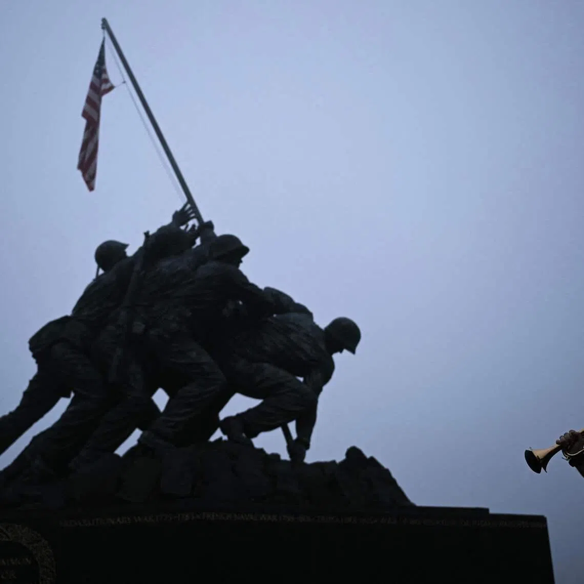 Ryan Brewer, a military bandsman and member of the Doughboy Foundation, playing "Taps" at the Marine Corps War Memorial to mark Memorial Day in Arlington, Virginia, U.S on May 25, 2026. 