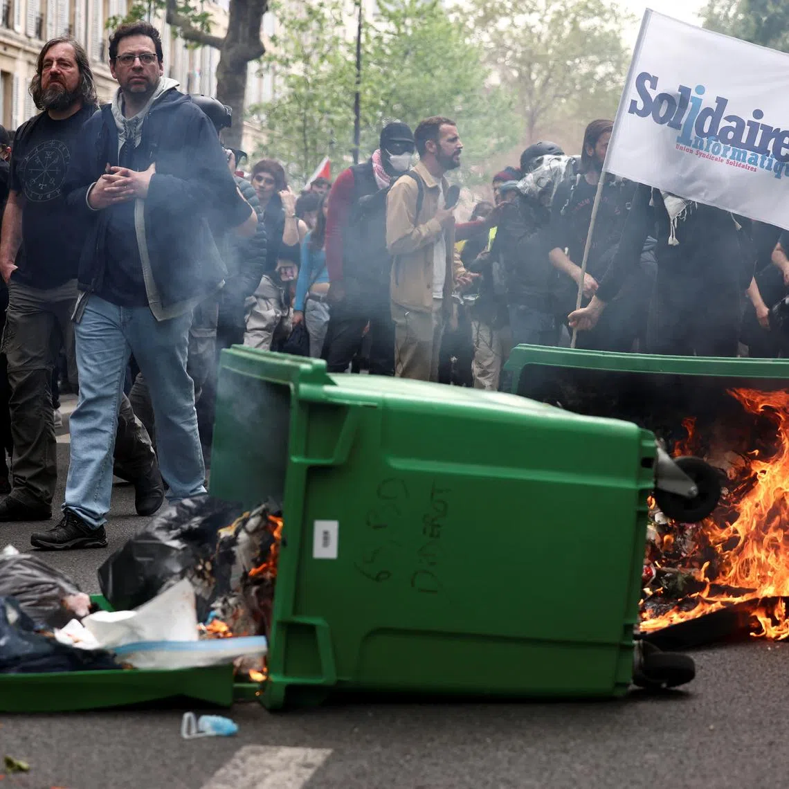 A dumpster on fire as people attend the traditional May Day labour union march in Paris, France, May 1, 2024. REUTERS/Stephanie Lecocq