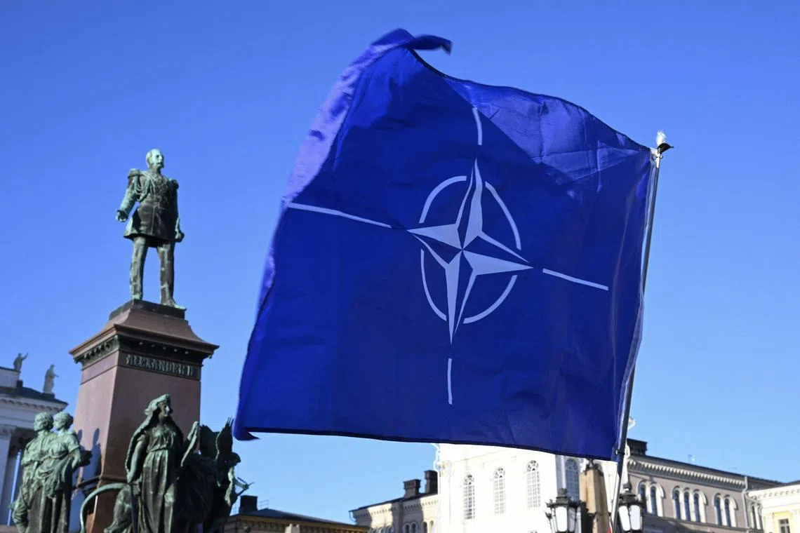 People waving the Nato flag in Helsinki on April 4, the day Finland became a member of Nato. Sweden’s Nato bid still faces opposition.