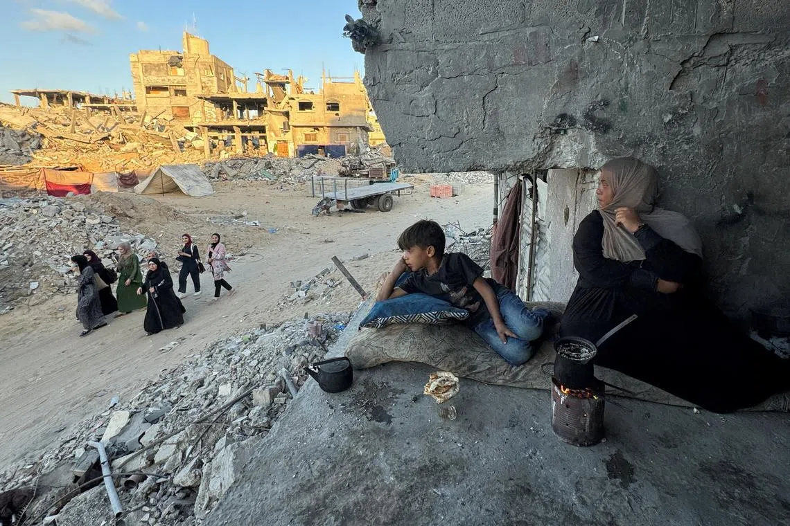 Palestinians sit at their house which was destroyed in an Israeli strike in Khan Younis, in the southern Gaza Strip, May 29, 2024. REUTERS/Mohammed Salem