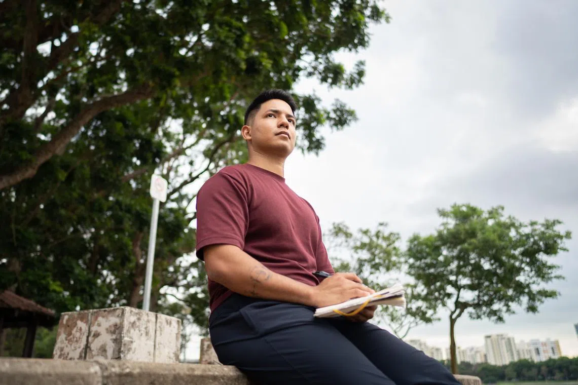 akmental16 - Daniel Paul Anugraham, 24, remote strength and performance coach, journalling down his thoughts and emotions as a way of taking care of his mental health at Bedok Reservoir Park on 11 November, 2022.

ST PHOTO: SYAMIL SAPARI