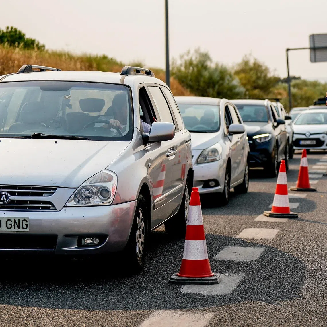 Cars queue on the M-501 highway as police blocks access due to wildfires affecting the area, in Madrid, Spain, July 25, 2026. REUTERS/Ana Beltran