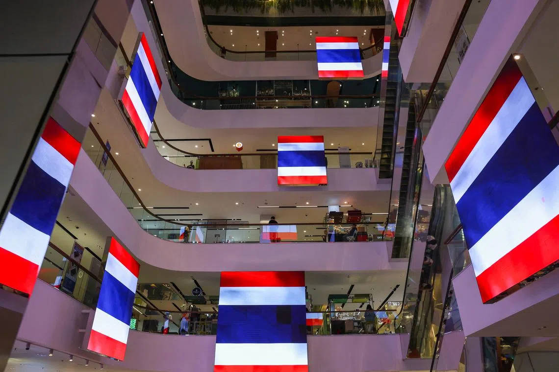 FILE PHOTO: A view shows digital screens showing Thai national flags in support of the country inside a shopping mall, on the day the leaders of Cambodia and Thailand agreed to a ceasefire effective midnight, in a bid to bring an end to their deadliest conflict in more than a decade after five days of fighting, in Bangkok, Thailand, July 28, 2025. REUTERS/Chalinee Thirasupa/File Photo