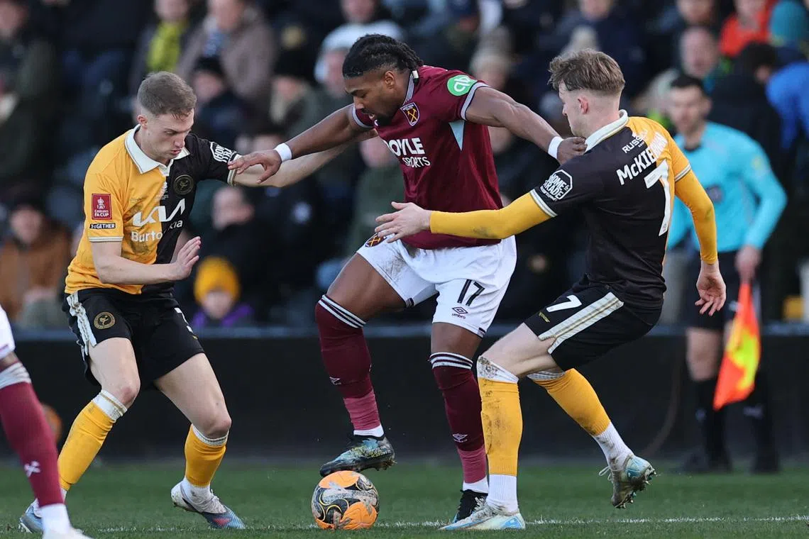 Soccer Football -  FA Cup - Fourth Round - Burton Albion v West Ham United - Pirelli Stadium, Burton-on-Trent, Britain - February 14, 2026 West Ham United's Adama Traore in action with Burton Albion's Jack Armer and Jj Mckiernan Action Images via Reuters/Andrew Boyers