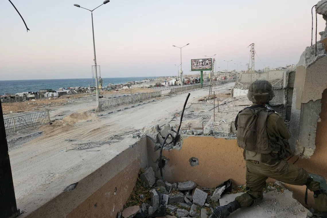 Israeli military personnel that a small group of journalists were permitted to accompany in northern Gaza for a few hours hold a position within sight of the coast on Saturday.