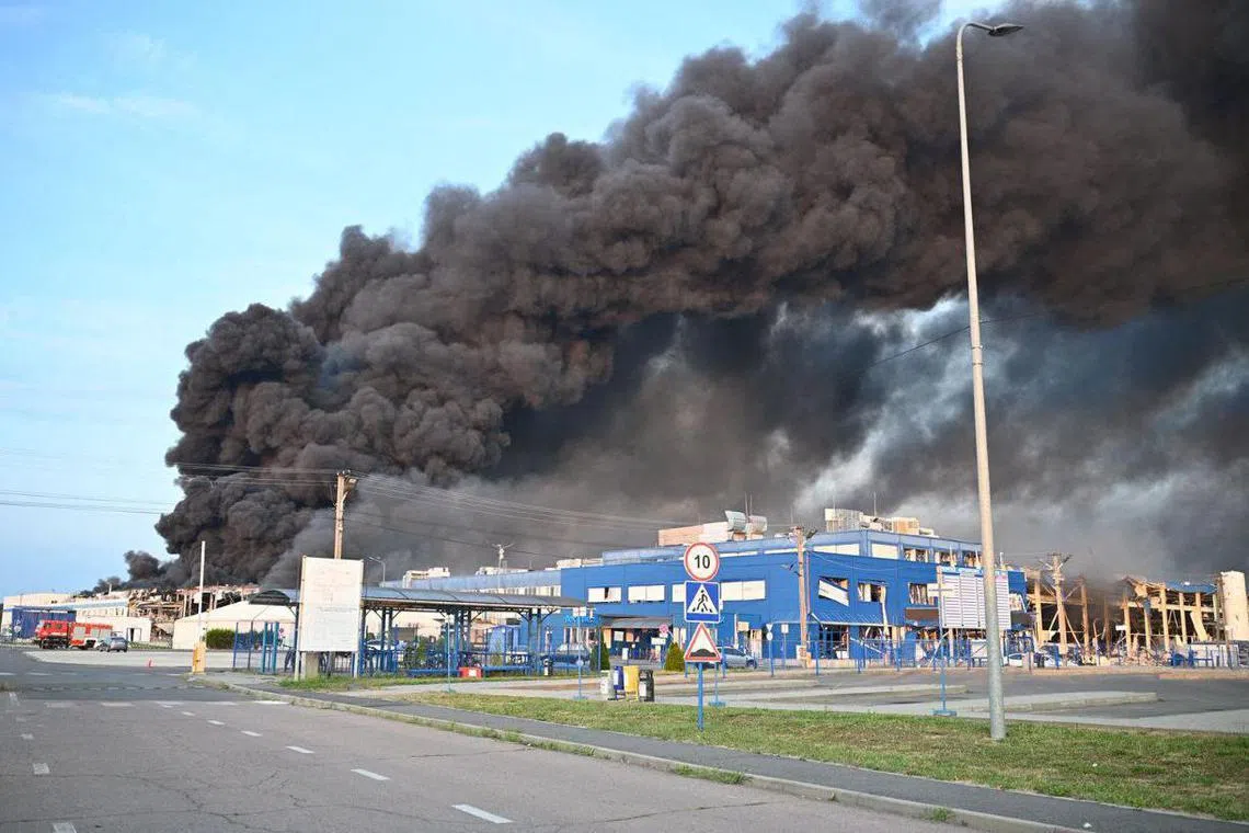 Smoke rising over buildings following a Russian air attack on a US-owned business in Ukraine's Zakarpattia region on Aug 21. 