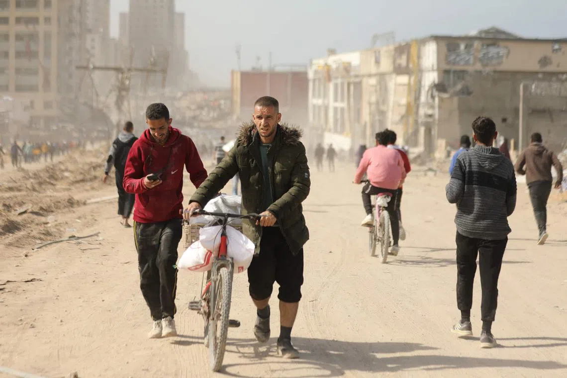 Palestinians transport bags of flour as humanitarian aid arrives in Gaza City on March 6. 