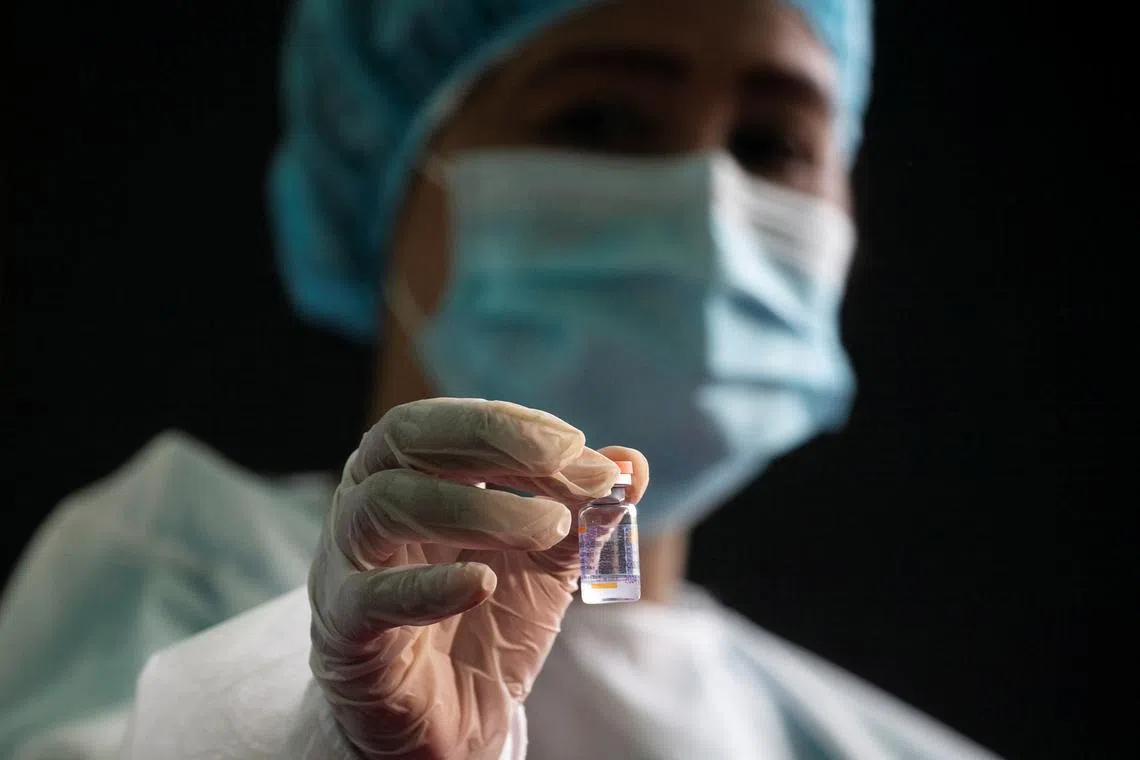 FILE PHOTO: A health worker shows a vial of Sinovac Biotech’s Coronavac during the vaccination of Philippine military at the national headquarters of the Philippine Army in Fort Bonifacio, Taguig City, Metro Manila, Philippines, March 2, 2021. REUTERS/Eloisa Lopez/File Photo
