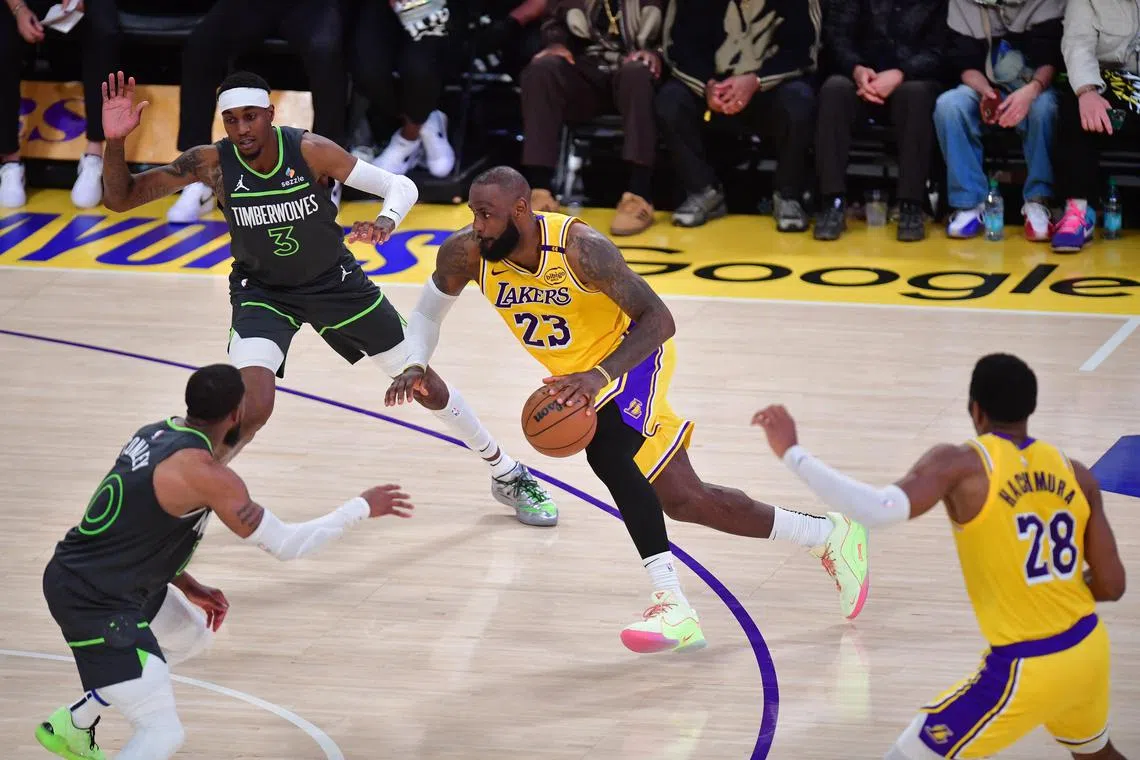 Los Angeles Lakers forward LeBron James moves to the basket against Minnesota Timberwolves forward Jaden McDaniels and guard Mike Conley during the second half in Game 5.