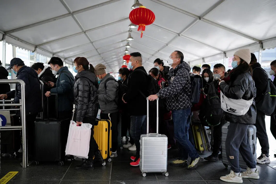 People walk with their luggage at a railway station during the annual Spring Festival travel rush ahead of the Chinese New Year, as the Covid-19 outbreak continues in Shanghai, China. 