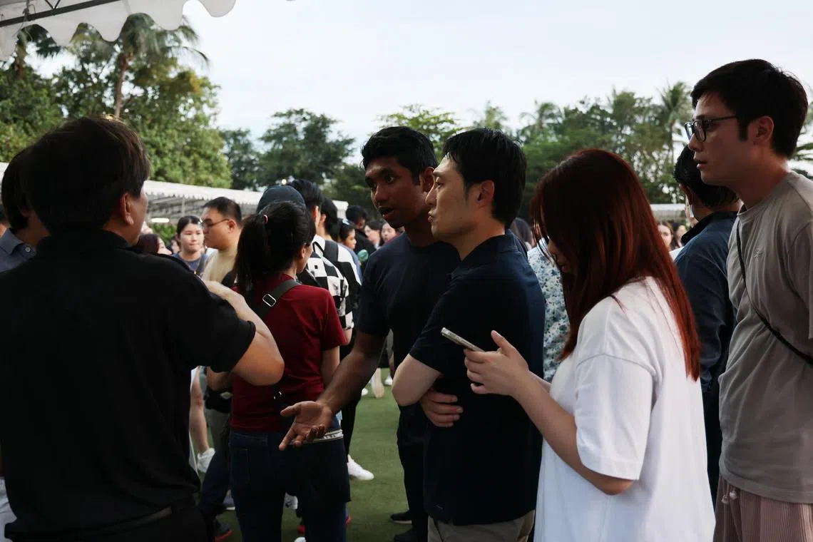  Attendees speaking with event staff at the Sky Lantern Festival at Sentosa on Feb 21, 2024. 