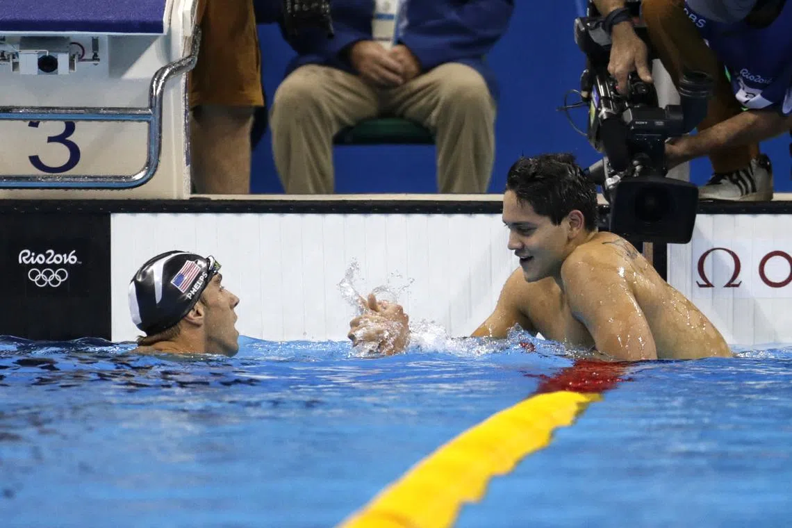 Singapore swimmer Joseph Schooling (right) being congratulated by United States' swimming legend Michael Phelps after winning the Rio 2016 Olympic Games men's 100m butterfly final at the Olympic Aquatics Stadium in Rio de Janeiro, Brazil, on 13 August 2016.
