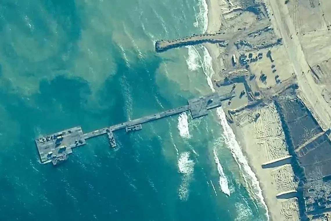 Members of the U.S. Army, U.S. Navy and the Israeli military put in place the Trident Pier, a temporary pier to deliver humanitarian aid, on the Gaza coast, amid the ongoing conflict between Israel and the Palestinian Islamist group Hamas, May 16, 2024.  U.S. Central Command/Handout via REUTERS