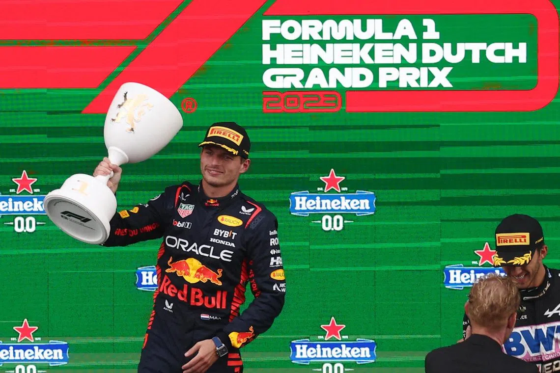 Red Bull's Max Verstappen celebrates with the trophy on the podium after winning the Dutch Grand Prix.