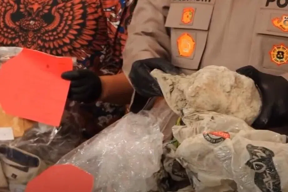 Officers at the Cilacap police station displaying the plastic, cement and sheets the Singaporean victim's body was found in.