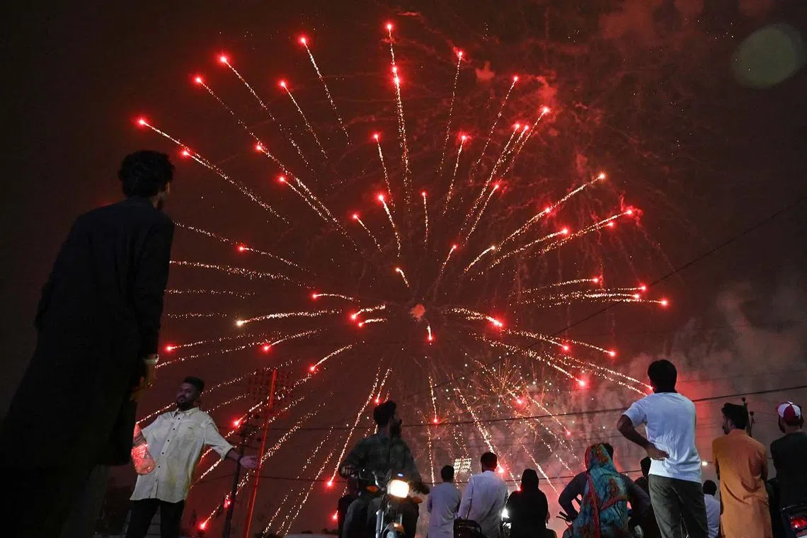 People watching fireworks in front of the National Stadium during Pakistan's 78th Independence Day in Karachi on Aug 14, 2025. 