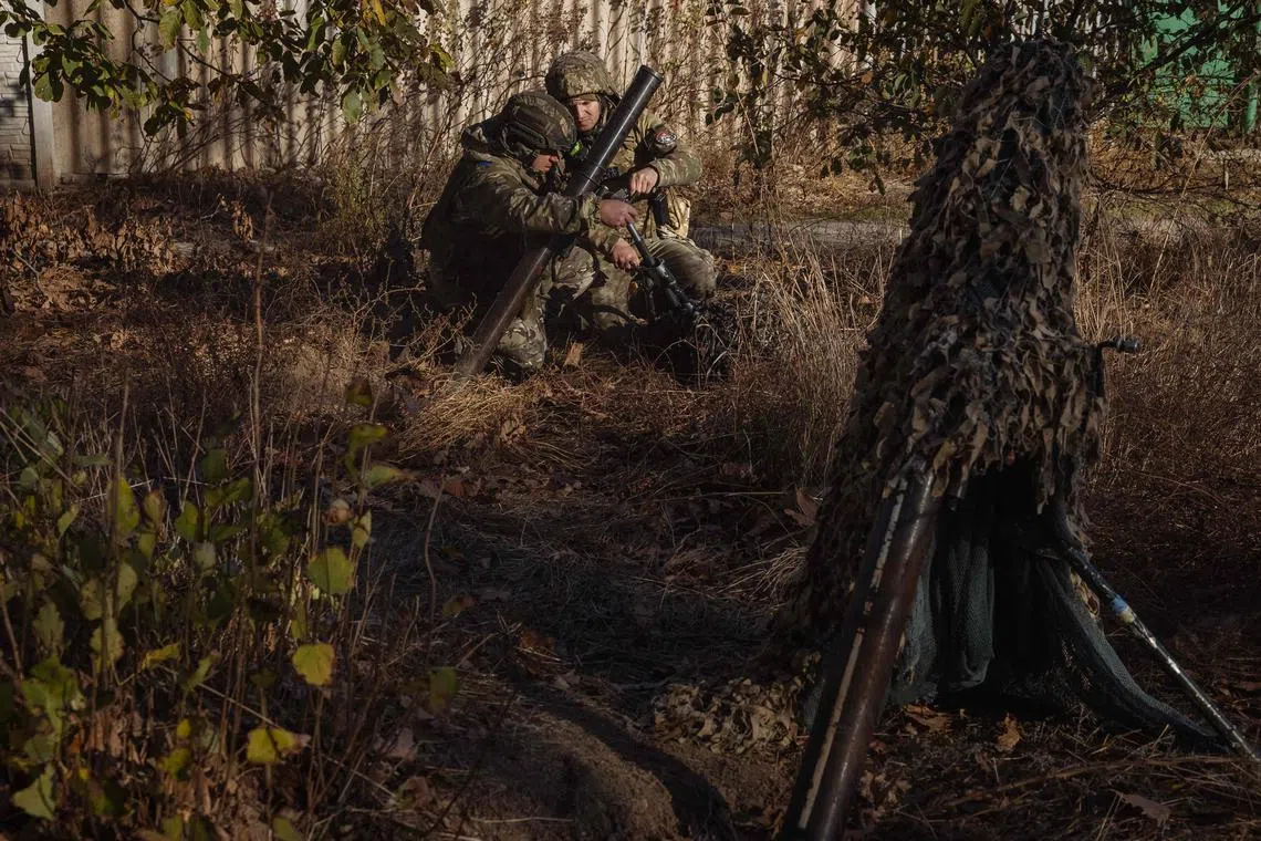Ukrainian servicemen prepare to fire a mortar over the Dnipro River towards Russian positions, in Ukraine's Kherson region.