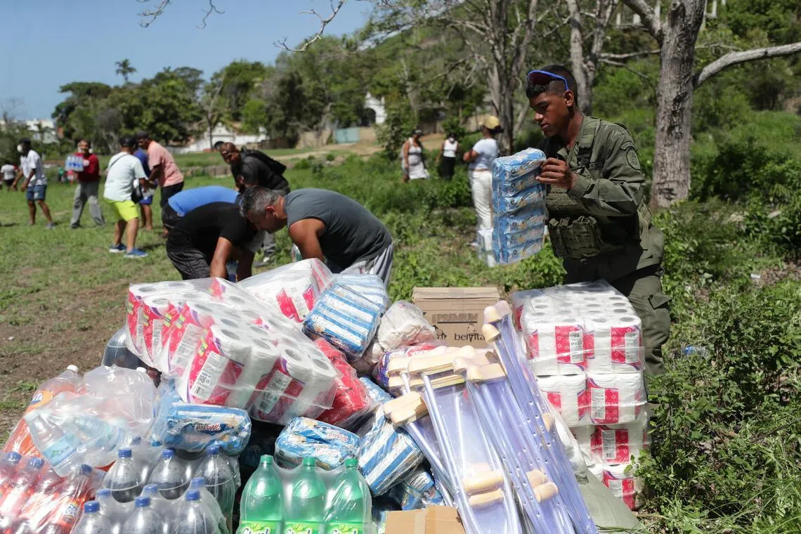 People unload humanitarian aid from a helicopter in La Guaira, Venezuela.