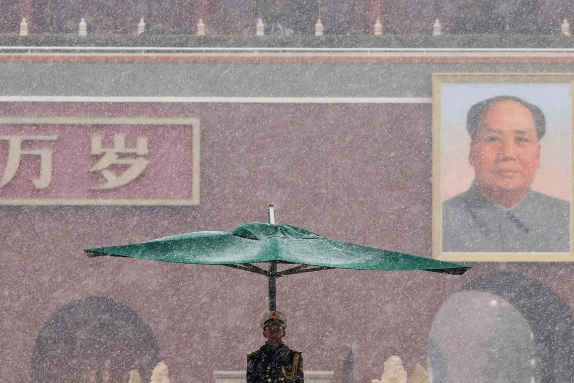 A People’s Liberation Army honour guard standing under an umbrella during heavy snowfall, with the Tiananmen Gate featuring a portrait of late Chinese Chairman Mao Zedong in the background, ahead of the annual National People's Congress (NPC), and the Chinese People's Political Consultative Conference (CPPCC), in Beijing, China, on March 4, 2026. 