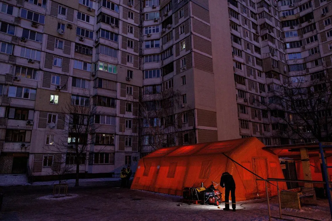 A State Emergency Service employee checks a generator next to a tent of a government-run humanitarian aid point, where residents can warm up, charge their devices, get hot drinks and psychological support, installed next to apartment buildings during a power blackout after critical civil infrastructure was hit by overnight Russian missile and drone strikes, amid Russia's attack on Ukraine, in Kyiv, Ukraine, January 20, 2026. REUTERS/Valentyn Ogirenko