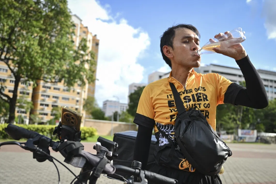 Delivery rider says frequent water breaks help him cope with the heat