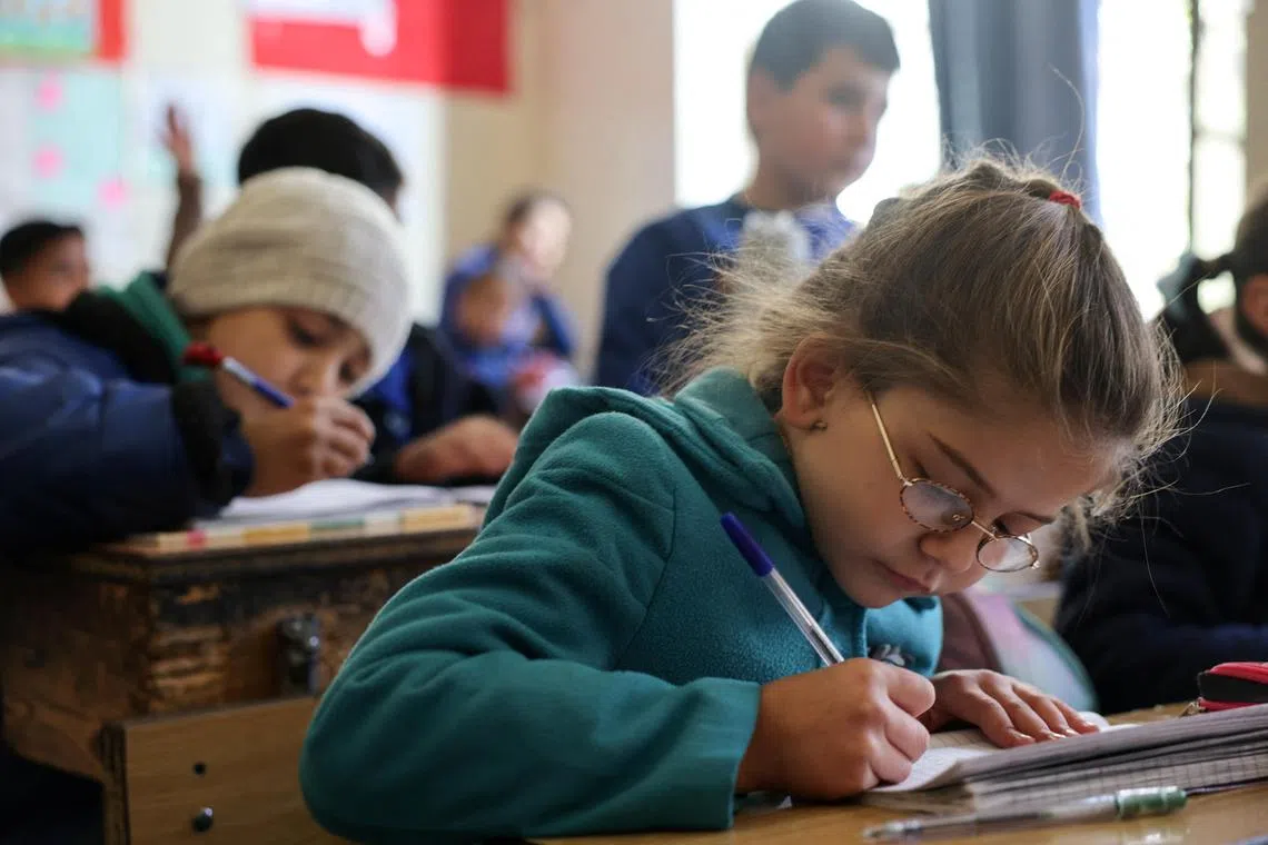 Students sitting in a classroom at a school following an announcement of the reopening of schools by the authorities in Damascus, Syria, on Dec 19, 2024. 