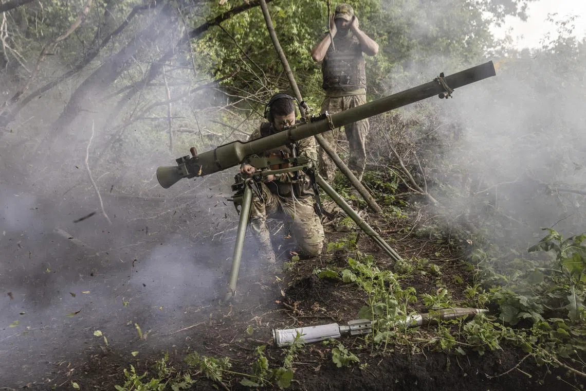 Ukrainians soldiers fire an SPG-9 recoilless gun towards Russian positions near Prechystivka, in the Donetsk region of Ukraine.