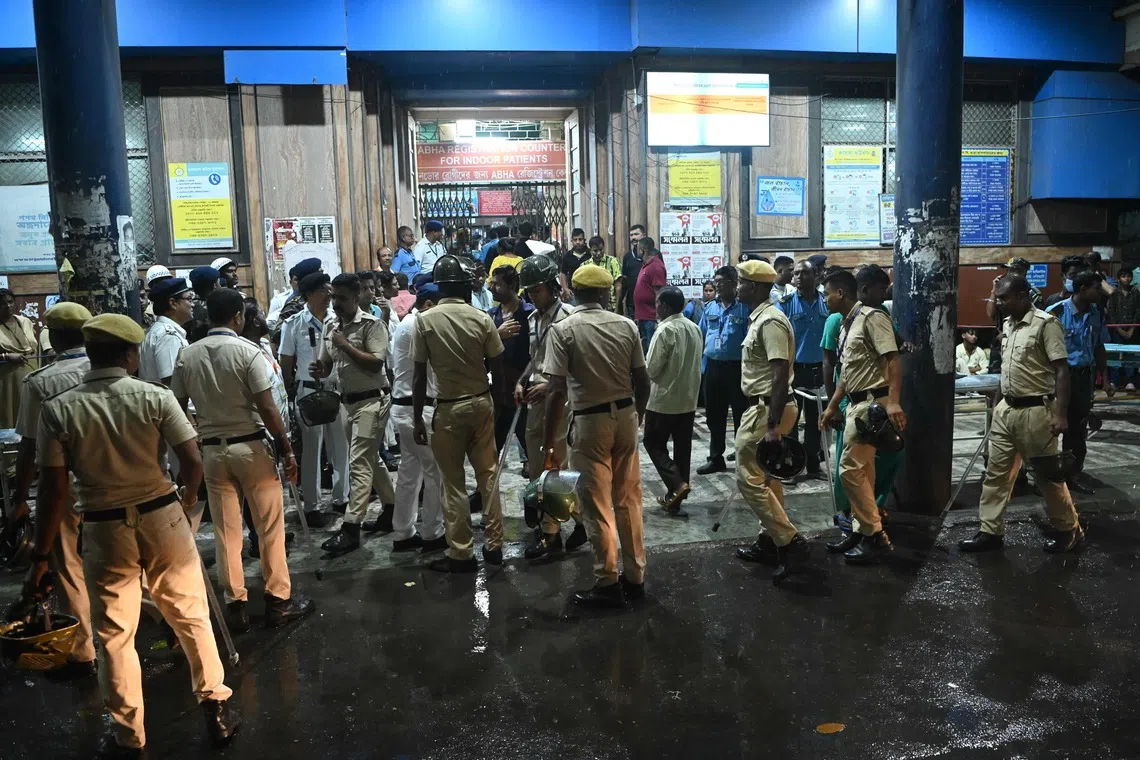 Police and emergency workers stand near the emergency building of Calcutta Medical College and Hospital as relatives of Durga Puja stampede victims mourn, in Kolkata, on Oct 16.