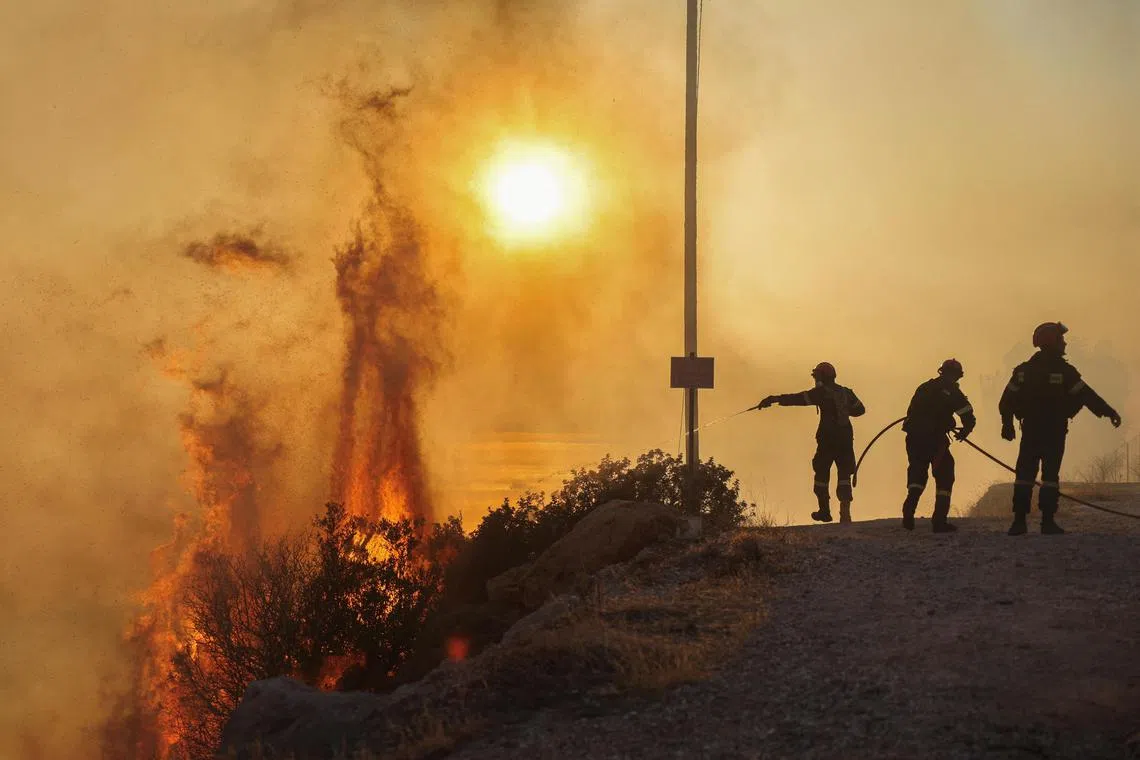 Firefighters try to extinguish a wildfire burning in Saronida, near Athens, Greece, July 17, 2023. REUTERS/Stelios Misinas     TPX IMAGES OF THE DAY     