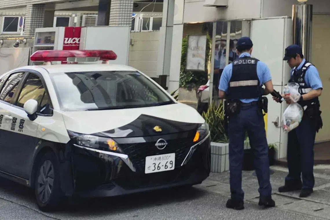 Police officers near a hotel where a woman was found dead in Naha, in Japan’s Okinawa prefecture, on Oct 4.