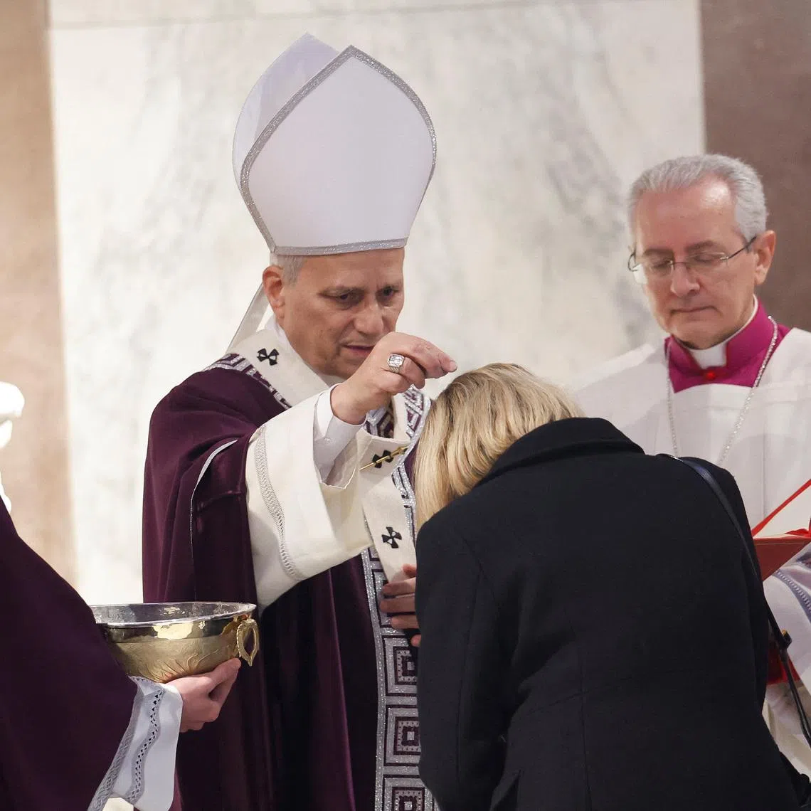 Pope Leo XIV puts ash on a faithful's head during the Ash Wednesday Mass at the Santa Sabina Basilica in Rome, Italy, February 18, 2026. REUTERS/Remo Casilli