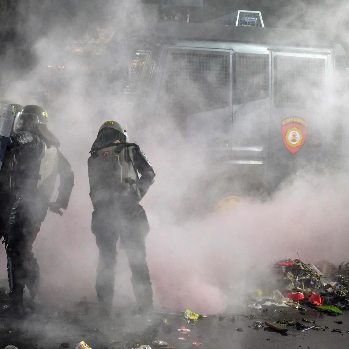 Riot police put out a fire during following clashes during protest against a rise in non-subsidised fuel prices, inefficient government spending and military involvement in civilian affairs.