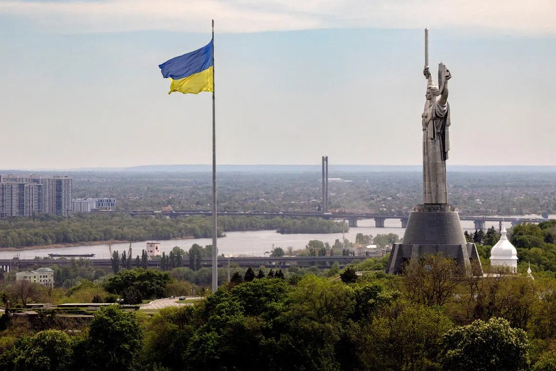 The Ukrainian national flag flies near the Motherland monument at the National Museum of the History of Ukraine in the Second World War, amid Russia’s attack on Ukraine, in Kyiv, Ukraine, May 8, 2026. REUTERS/Thomas Peter