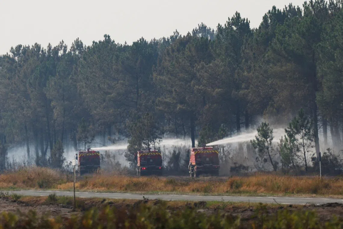 Firefighting vehicles work to extinguish a fire inside a military base during a wildfire in France.