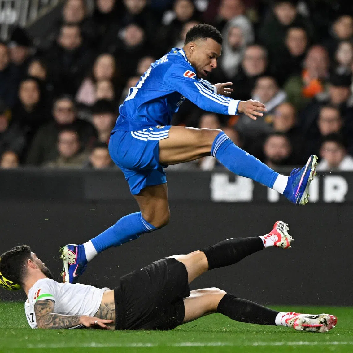 Soccer Football - LaLiga - Valencia v Real Madrid - Estadio de Mestalla, Valencia, Spain - February 8, 2026 Real Madrid's Kylian Mbappe in action with Valencia's Unai Nunez REUTERS/Pablo Morano