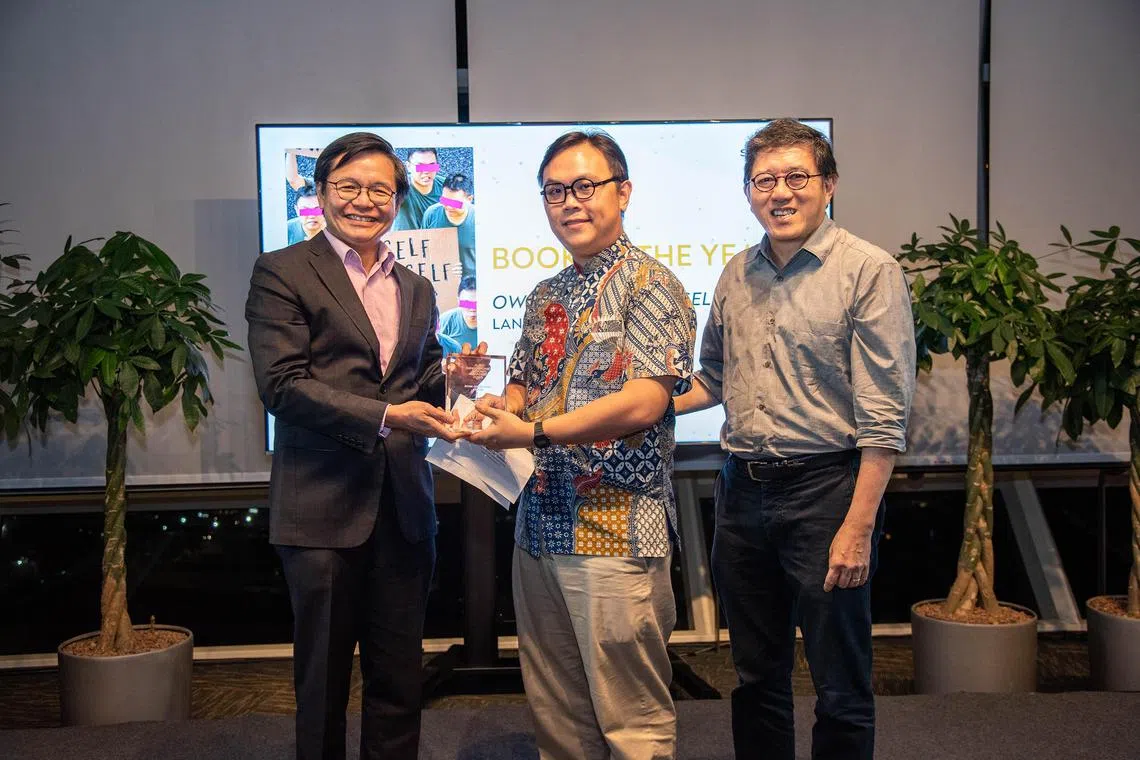 Poet Joshua Ip (centre) receiving the prize for Book of the Year from National Library Board chief executive Mr Ng Cher Pong at the Singapore Book Awards on July 25. On the right is Landmark Books publisher Mr Goh Eck Kheng.  