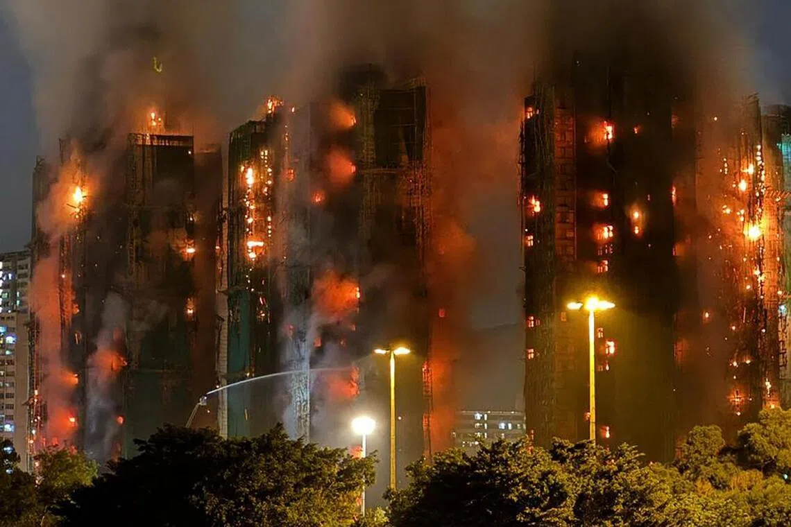 (FILES) Thick smoke and flames rise as a major fire engulfs several apartment blocks at the Wang Fuk Court residential estate in Hong Kong's Tai Po district on November 26, 2025. An independent committee investigating a devastating fire that ripped through a Hong Kong housing complex last year began a series of public hearings on march 19, 2026, into the blaze that killed 168 people. (Photo by Yan ZHAO / AFP)