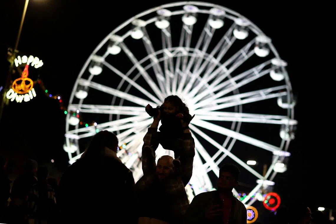 People taking photos on the Golden Mile during Diwali celebrations in Leicester, Britain, on Oct 31, 2024. 
