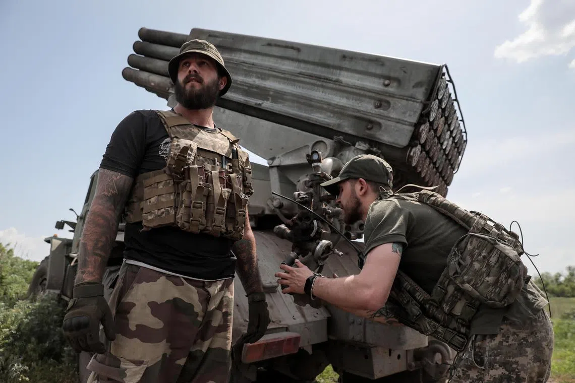 Ukrainian servicemen from the 24th Mechanised Brigade 'King Danylo' prepare a BM-21 'Grad' multiple rocket launcher system (MLRS) before firing in the direction of the frontline city of Bakhmut, at an undisclosed location in eastern Ukraine, on May 19 2023.